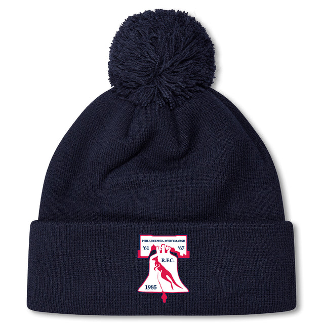 The Philly Whitemarsh RFC Pom Pom Beanie by EMB Canterbury features a navy knit design, fleece lining, pom-pom top, and a front patch with bell, bird, "R.F.C.," and years 1967 & 1985—perfect for chilly days.