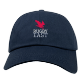 A Rugby East Conference Adult Low-Profile Cotton Twill Dad Cap by EMB Alpha Broder featuring a red bird graphic above the text "RUGBY EAST" embroidered in white, crafted from durable cotton twill for a comfortable fit.