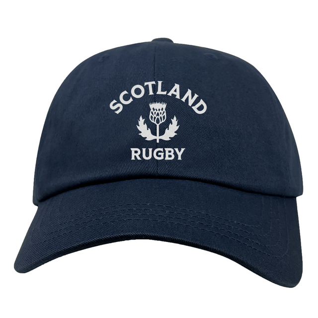 The EMB S&S Activewear Nations of Rugby Scotland Dad Cap features navy blue cotton twill and front white "SCOTLAND RUGBY" with thistle embroidery—a classic hat for rugby fans.