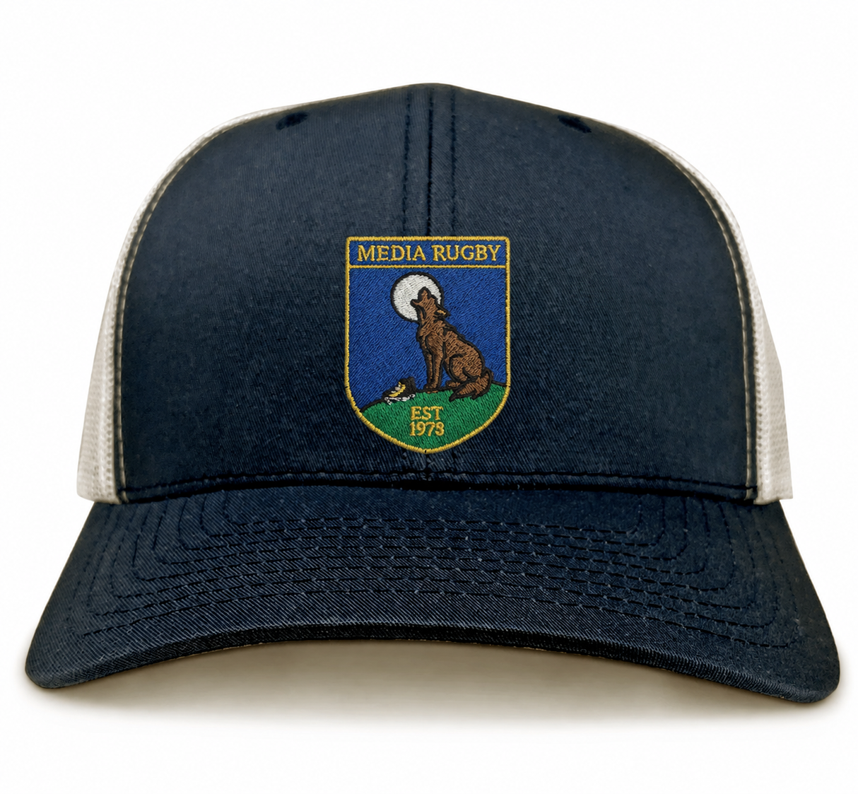 The Media Rugby Retro Trucker Cap by EMB S&S Activewear is a navy and white hat featuring a “Media Rugby” patch with a howling wolf, “Est 1973” text, and an adjustable snapback closure.