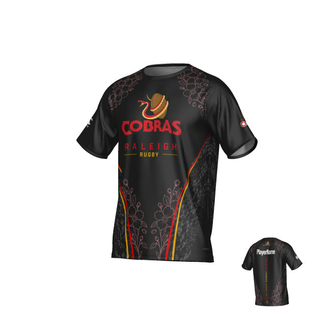 Sure! Here’s your rewritten sentence using the provided product data: The Raleigh Cobras Canterbury Legacy Performance Tee by Teamatical is a black rugby jersey showcasing “Cobras Raleigh Rugby” and a cobra logo on the front, highlighted with yellow and red accents, and featuring a customizable player name area on the back.