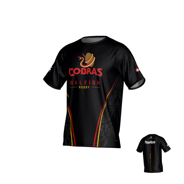 The Teamatical Raleigh Cobras Canterbury Eco-Sublimate Tee features a black design with red and gold accents, highlighted by the snake logo and team text on the front. Crafted from breathable, sustainable material using eco-sublimation, this rugby jersey includes a customizable name placeholder on the back.