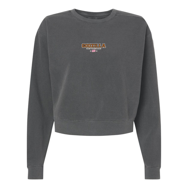 Introducing the Godzilla Rugby Football Club Women’s Garment-Dyed Mid-Length Crewneck Sweatshirt by EMB S&S Activewear. This dark gray, heavyweight fleece sweatshirt features a mid-length, slightly cropped silhouette for a contemporary look. The front center showcases “GORZILLA” and a gorilla graphic, making it a standout piece for any wardrobe.