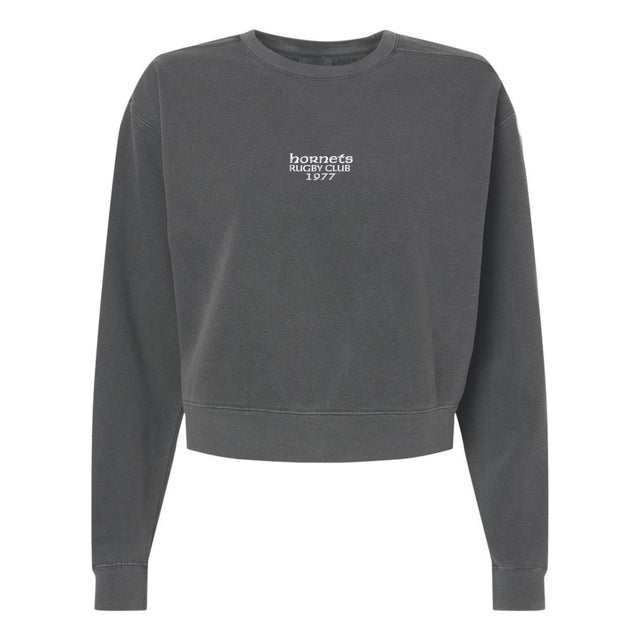 The EMB S&S Activewear Hornets Rugby Club 1977 Women’s Garment-Dyed Mid-Length Crewneck Sweatshirt features a dark gray color, small “hornets RUGBY CLUB 1977” print in white on the front center, and is crafted from heavyweight fleece for lasting comfort and warmth.