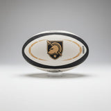 The Army West Point Gilbert Omega Match Ball by Gilbert displays a black and gold logo with helmet, sword, and star, set on a clear stand against a gray background.