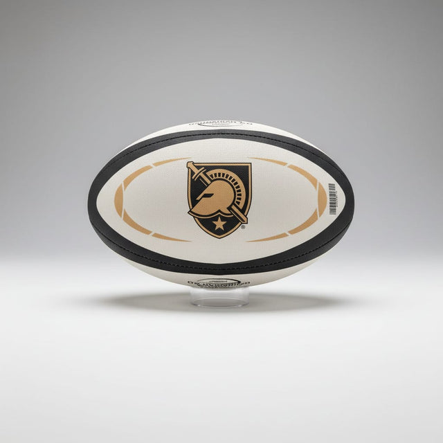 The Army West Point Gilbert Omega Match Ball by Gilbert displays a black and gold logo with helmet, sword, and star, set on a clear stand against a gray background.