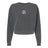 The Missoula All-Maggots Women’s Garment-Dyed Mid-Length Crewneck Sweatshirt by EMB S&S Activewear is a charcoal gray, long-sleeve heavyweight fleece sweatshirt with a cropped design and features a small white circular graphic at the center of the chest.