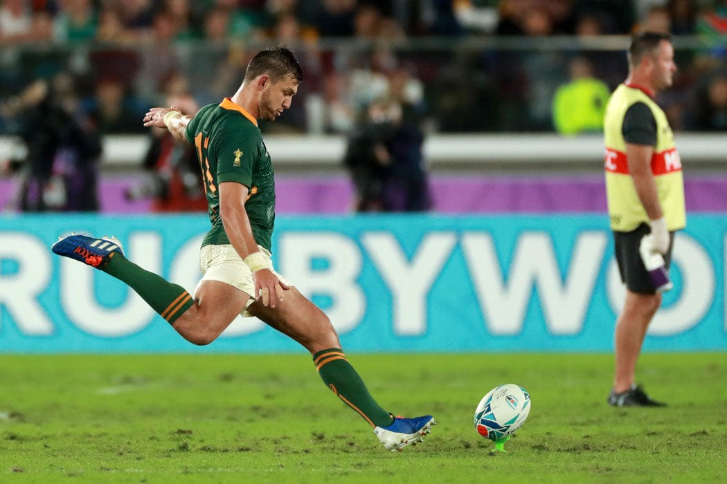 Rugby Player about to kick the ball