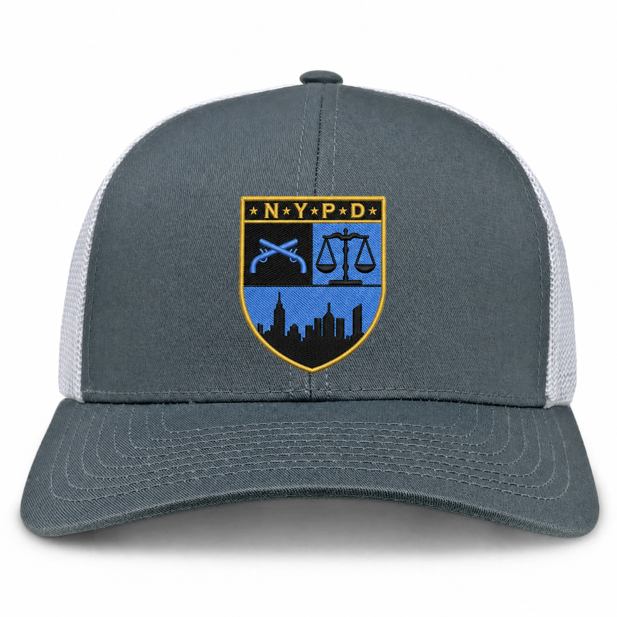 The New York Police Dept. Rugby Retro Trucker Cap by EMB S&S Activewear is a gray retro trucker cap with a mesh back and snapback closure, featuring an embroidered NYPD shield with a city skyline, scales of justice, and crossed batons on the front.
