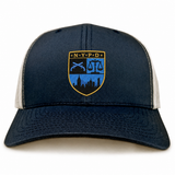 Introducing the New York Police Dept. Rugby Retro Trucker Cap by EMB S&S Activewear—a navy blue and white snapback featuring an embroidered NYPD shield with a city skyline, scales of justice, and crossed batons. Designed for an adjustable fit with its classic snapback closure, this cap blends timeless style and iconic details, perfect for true fans.