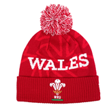 Red beanie with a white pom-pom from Fast Bundle's Welsh Fan Gift Set, featuring the "WALES" text and the Welsh Rugby Union logo on the cuff.
