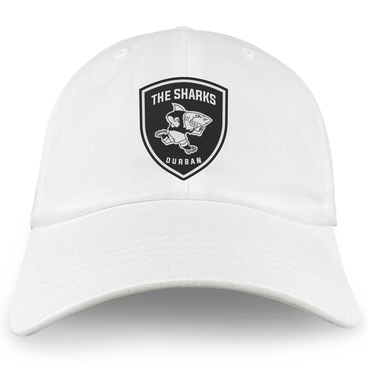 The Sharks Crest Cotton Twill Dad Cap by EMB S&S Activewear is a white dad cap with a black shark emblem and "THE SHARKS DURBAN" embroidered branding on the front.