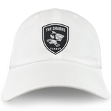 The Sharks Crest Cotton Twill Dad Cap by EMB S&S Activewear is a white dad cap with a black shark emblem and "THE SHARKS DURBAN" embroidered branding on the front.