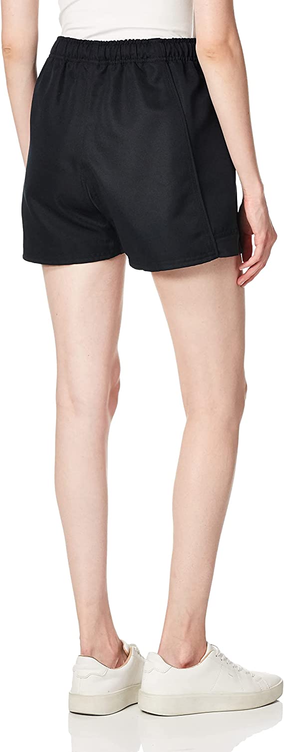 A person wearing a white top, Women's Canterbury Advantage Pro Rugby Shorts in black polyester, and white sneakers is standing with their back to the camera.
