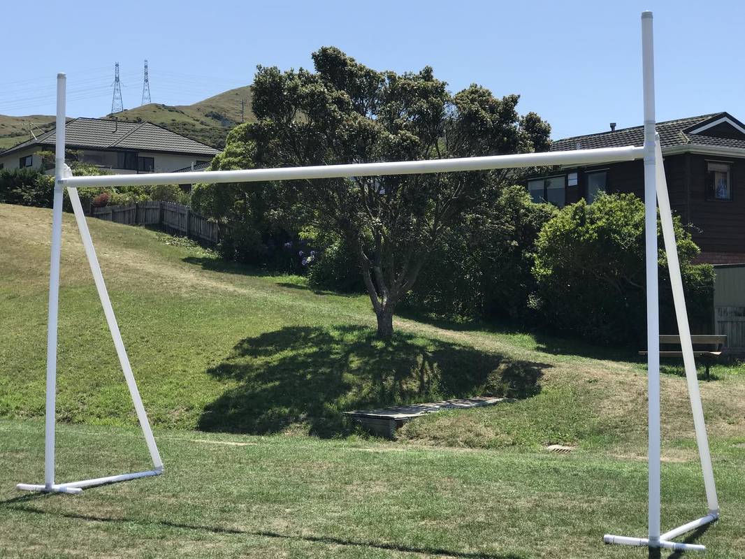 A Packaworld Packapost Full Sized Portable Rugby Post in the middle of a yard.