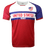 Round neck short sleeve jersey with white chest and upper left American flag in corner. Red right shoulder and sleeve and blue left shoulder and sleeve trimmed in red. Two horizontal blue stripes run across the chest. United States centered in red on the white jersey with Rugby in white on the blue stripe. The lower torso is red.