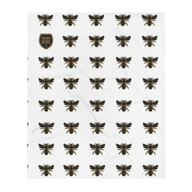 A white Rugby Hive Blanket with black bees on it.