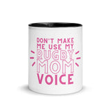 White ceramic mug with black interior and a pink 'don't make me use my rugby mom voice' inscription.