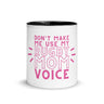 White ceramic mug with black interior and a pink 'don't make me use my rugby mom voice' inscription.