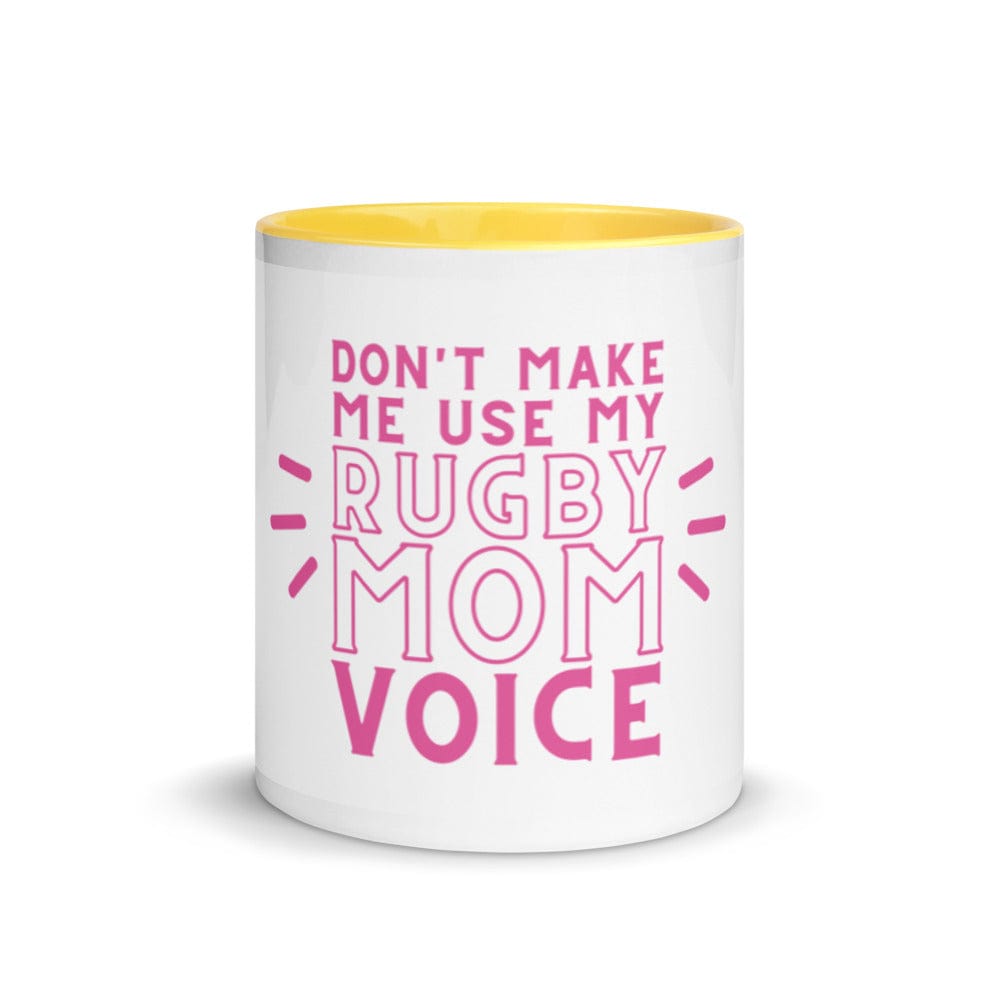 White ceramic mug with yellow interior and a pink 'don't make me use my rugby mom voice' inscription.