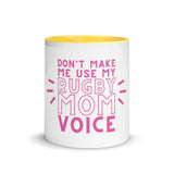 White ceramic mug with yellow interior and a pink 'don't make me use my rugby mom voice' inscription.