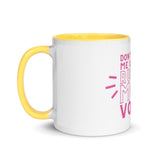 Side view of a white mug with yellow interior and handle.