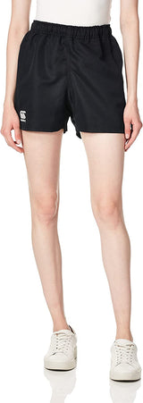A person is wearing Canterbury's Women's Advantage Pro Rugby Shorts against a plain background. The black shorts made from sleek polyester offer moisture management for ultimate comfort, paired with a white top and sneakers.